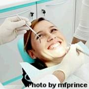 Frau lächelt auf dem Zahnarztstuhl