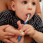 Mutter putzt Kind die Zähne