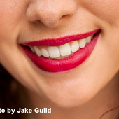 Lächelnder Mund mit pinkem Lippenstift geschminkt
